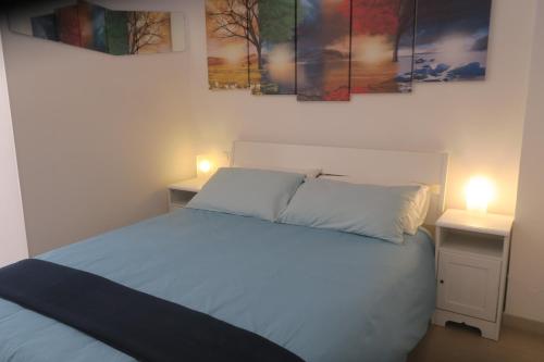 een slaapkamer met een bed met twee nachtkastjes en twee lampen bij Namastè monolocale in Ancona