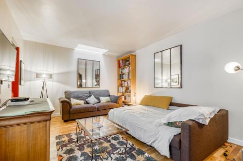 een woonkamer met een bed en een bank bij Une maison comme un Riad in Vincennes