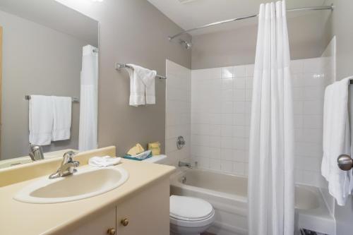 a bathroom with a sink and a toilet and a tub at Motel 6-Saanichton, BC - Victoria Airport in Saanichton