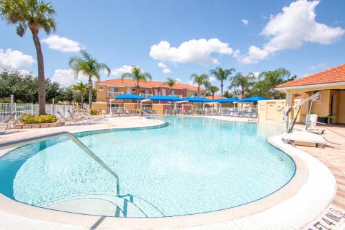 ein großer Pool mit blauen Sonnenschirmen in einem Resort in der Unterkunft Berkley Lake Townhomes in Kissimmee