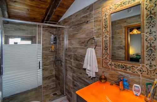 a bathroom with a shower and a sink and a mirror at Eleni Country Cottage 2 in Feneos
