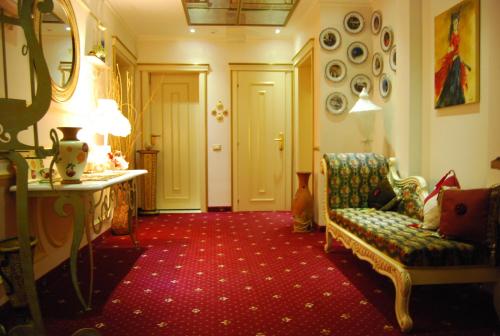 a living room with a chair and a mirror at 2 KITARRAT Boutique Hotel & SPA in Durrës