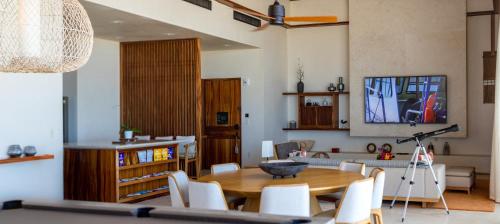 a living room with a wooden table and white chairs at Nobu Hotel Los Cabos in Cabo San Lucas