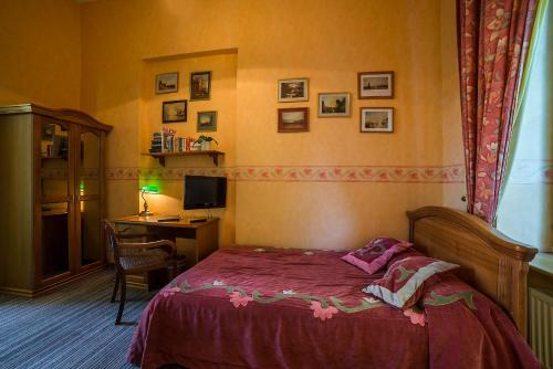 a bedroom with a bed and a desk with a computer at Shakespeare Boutique Hotel in Vilnius