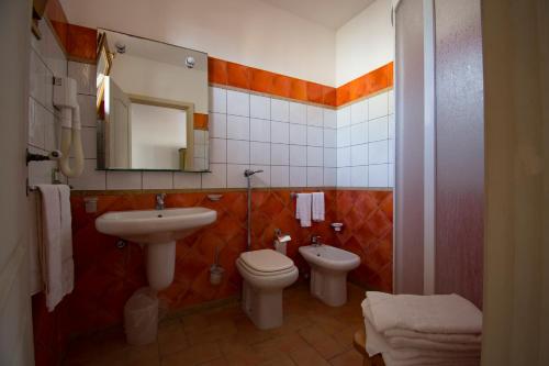 a bathroom with a sink and a toilet and a mirror at Maragani Beach in Maragani