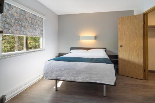 a bedroom with a bed and a window at Motel 6-Saanichton, BC - Victoria Airport in Saanichton