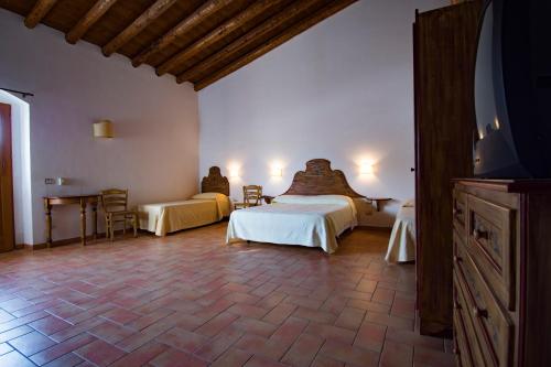 a bedroom with two beds and a table and a tv at Maragani Beach in Maragani