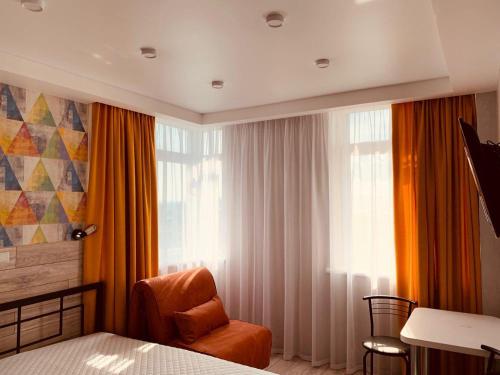 um quarto com uma cama, uma cadeira e uma janela em Doba In Ua Luhovska255 Apartments em Dnipro