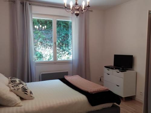 Schlafzimmer mit einem Bett und einem Fenster in der Unterkunft Ma villa au bord de l'eau in Miremont
