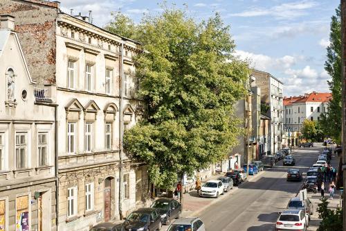 Smart Rooms for Rent في كراكوف: شارع المدينة فيه سيارات متوقفة بجانب مبنى