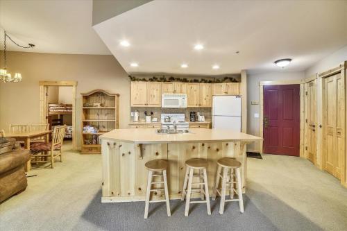 a kitchen with a large island with bar stools at Tucker Mountain Lodge 102 Condo in Copper Mountain