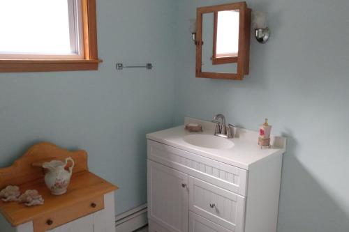 W łazience znajduje się umywalka, lustro i krzesło. w obiekcie The Open Door in Jefferson NY w mieście Jefferson