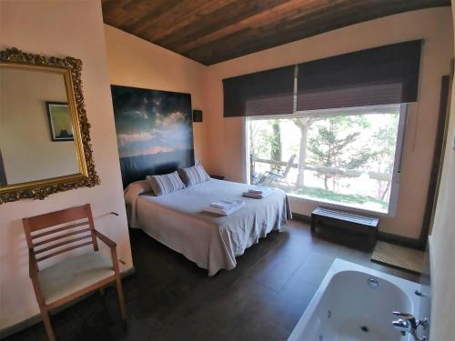 アルカラスにあるCasas Rurales Los Cortijosのベッドルーム1室(ベッド1台、バスタブ、窓付)