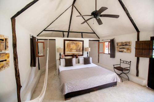 sypialnia z łóżkiem i wentylatorem sufitowym w obiekcie Hotel Hacienda Ticum w mieście Ekmul