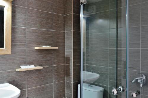 a bathroom with a shower and a toilet and a sink at Katerina Apartments in Kato Daratso