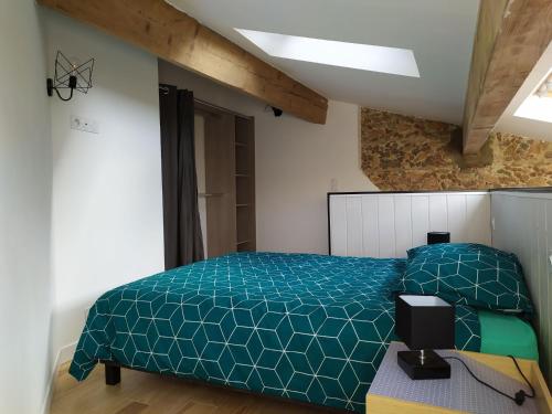 a bedroom with a bed with a blue comforter at Wine Loft 66 in Baixas