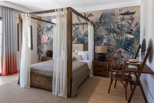 a bedroom with a canopy bed with a table and a desk at Zigo's Hotel in Mugla
