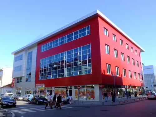 a red building with people walking in front of it at Hotel Vidović in Banja Luka