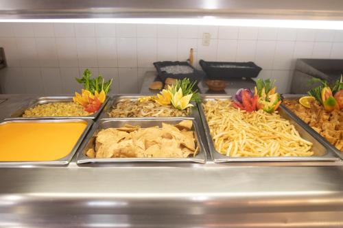 a row of trays of food in a kitchen at Qualton Club Ixtapa All Inclusive in Ixtapa