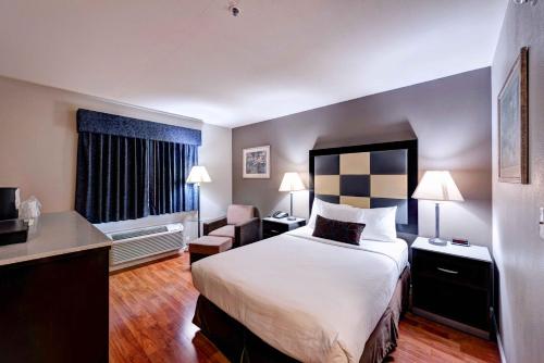 a hotel room with a bed and a desk at SureStay Plus Hotel by Best Western Redding in Redding