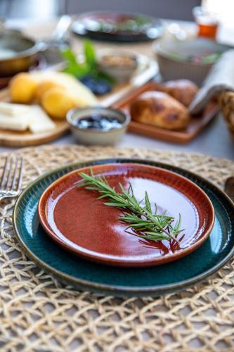 a plate with a sprig of rosemary on a table at Zigo's Hotel in Mugla