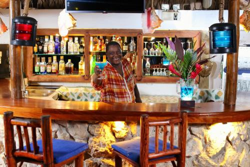 a man standing at a bar taking a picture at Villa Caribe in Lívingston