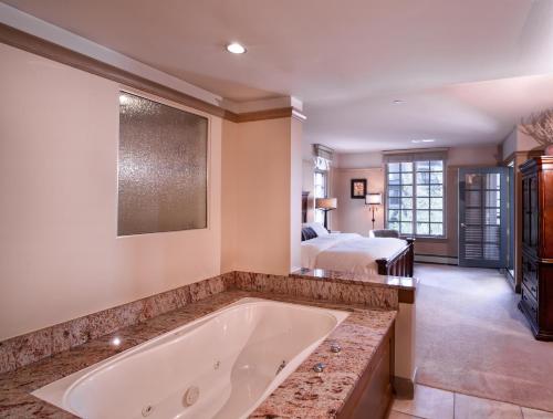 a large bathroom with a tub and a bed at Park Plaza Beaver Creek in Beaver Creek
