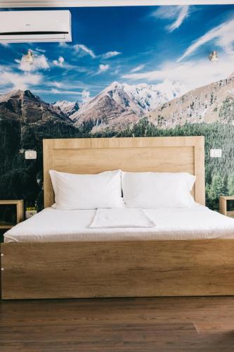 a bedroom with a bed with a view of mountains at La Tusi Lovrin in Lovrin