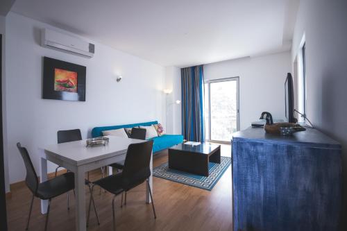 a living room with a table and a blue couch at Quinta De Santana in Rabo de Peixe