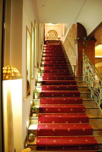 a stairway with red carpeted stairs in a building at 2 KITARRAT Boutique Hotel & SPA in Durrës