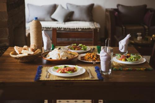 una mesa de madera con platos de comida. en Dar Ait Bouguemez en Azilal