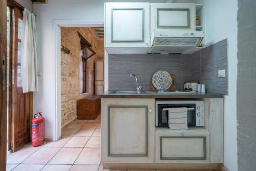 a kitchen with a sink and a microwave at Lemon Garden Residence in Heraklio Town