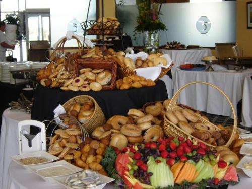 a table topped with baskets of bread and vegetables at MERLOT SUNSET The BEST Bed and Breakfast in Rideau Lakes in Portland