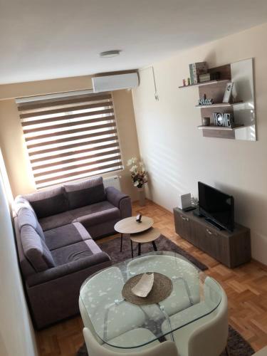 un soggiorno con divano e tavolo di Mirkovic Lux apartman a Niš
