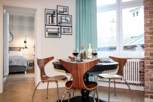 jadalnia ze stołem z krzesłami i kieliszkami do wina w obiekcie Dominican Square by Hashtag Apartments w Krakowie