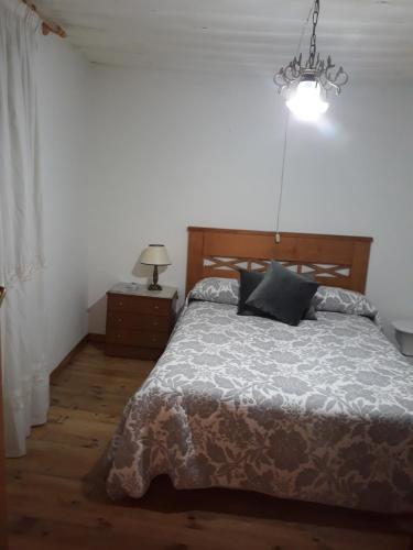 - une chambre avec un lit et un lustre dans l'établissement Casa Da Carme, à Casela