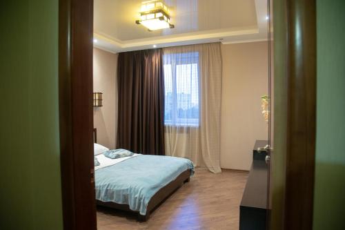 a hotel room with a bed and a window at Квартира Люкс in Vinnytsya