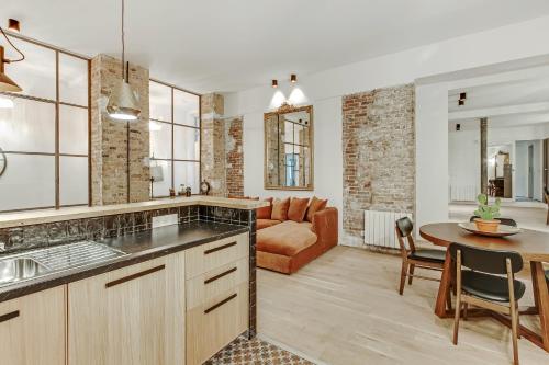 Il comprend une cuisine et un salon avec une table et un canapé. dans l'établissement Pick A Flat's Apartment in Louvre Saint Honoré, à Paris