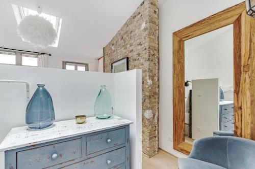 Cette chambre comprend une commode bleue et un miroir. dans l'établissement Pick A Flat's Apartment in Louvre Saint Honoré, à Paris