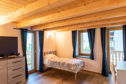 奧斯塔的住宿－Rayon de Miel，一间卧室设有一张床、一台电视和窗户。