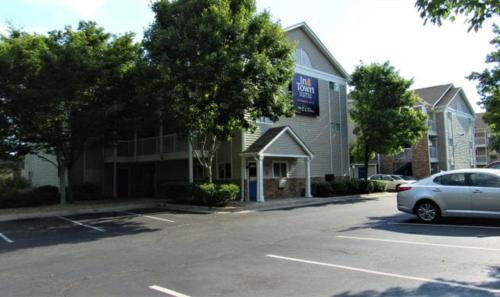 a car parked in a parking lot in front of a building at InTown Suites Extended Stay Atlanta GA - Roswell Alpharetta in Roswell