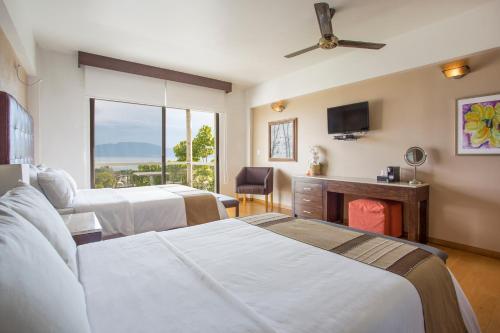 een hotelkamer met twee bedden en een televisie bij Donaire Hotel Boutique in Ajijic