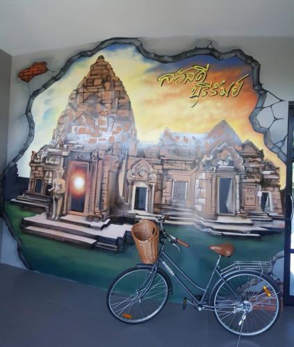 a bike parked in front of a painting of a building at Sawasdee​ Buriram​ Resort in Buriram