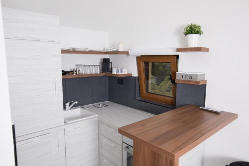 a kitchen with white cabinets and a wooden counter top at Apart 31 in Cetinje