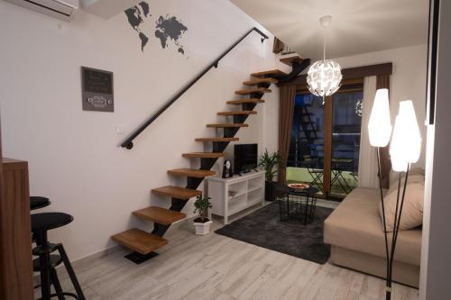 a living room with a spiral staircase and a couch at Apart 31 in Cetinje