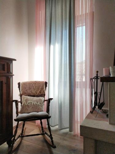a chair sitting in front of a window with curtains at Casa Violina in San Pietro Avellana