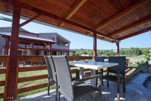 a patio with a table and chairs under a wooden roof at Apartments Šeherzada in Pula