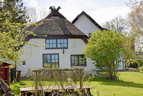 ein großes weißes Haus mit einem Strohdach in der Unterkunft Ferienhaus und -wohnung unterm Reetdach in Woorke in Hof Patzig