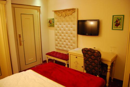 a bedroom with a bed and a desk and a chair at 2 KITARRAT Boutique Hotel & SPA in Durrës