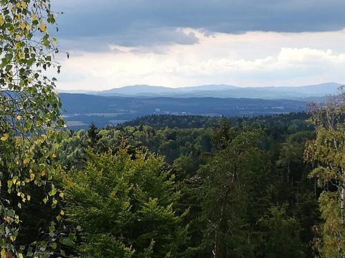 a view of a valley with mountains and trees at Novohradský ráj aneb Oáza klidu na samotě u lesa in Benešov nad Černou